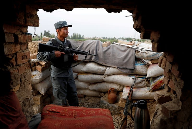 FILE PHOTO: Afghan policeman keeps watch at the check post on the outskirts of Kabul