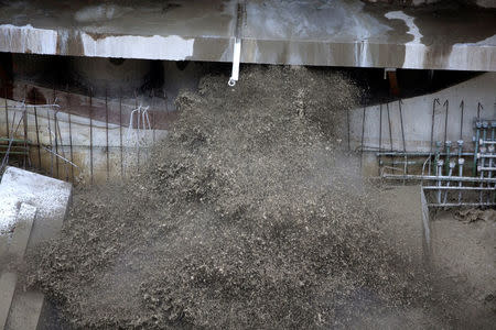 Water from Seattle’s tunnel-drilling machine, Bertha, the world's largest tunnel-boring machine starts breaking through the concrete wall from the bottom creating massive dust in the disassembly pit in Seattle, Washington, U.S., April 4, 2017. REUTERS/Karen Ducey