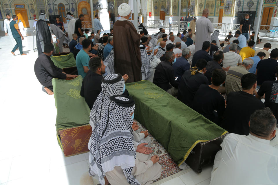 Mourners prepare to bury hospital fire victims in Najaf, Iraq, Tuesday, July 13, 2021. A catastrophic blaze erupted at a coronavirus hospital ward in southern Iraq of Nasiriyah on Monday. It was the second time a large fire killed coronavirus patients in an Iraqi hospital this year. (AP Photo/Anmar Khalil)