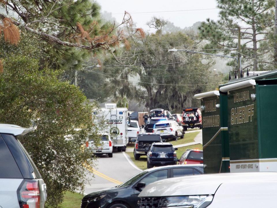 A SWAT team and Volusia County deputies surround a Deltona home at 3230 Whitehorse Court Wednesday. A shoplifting suspect barricaded himself in the home after shooting at deputies, injuring one.