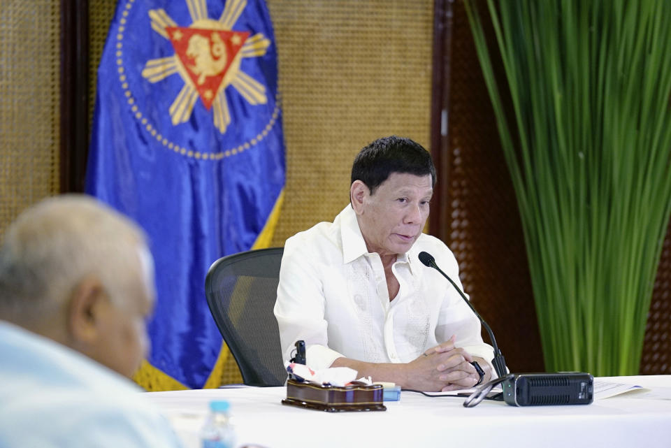 In this photo provided by the Malacanang Presidential Photographers Division, Philippine President Rodrigo Duterte, right, speaks during a meeting with government officials at the Malacanang presidential palace in Manila, Philippines on Monday May 23, 2022. Outgoing Philippine President Rodrigo Duterte sharply criticized Russian leader Vladimir Putin for the killings of innocent civilians in Ukraine, saying while the two of them have been tagged as killers, “I kill criminals, I don’t kill children and the elderly.” (King Rodriguez/ Malacanang Presidential Photographers Division via AP)