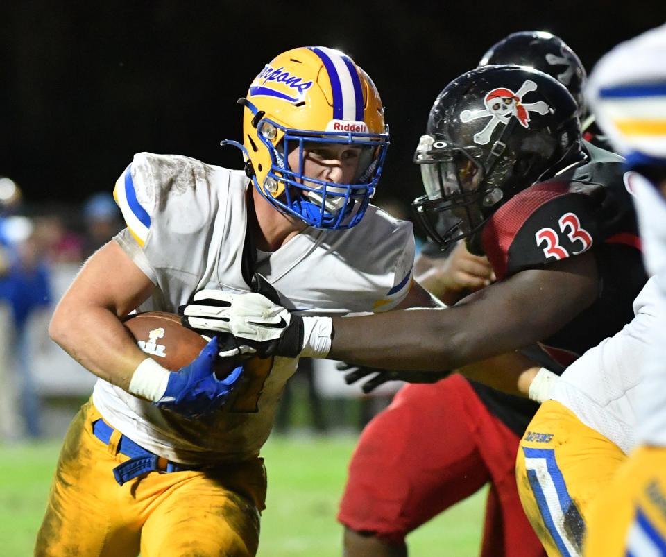 Charlotte High running back Connor Trim (#21) is met at the line of scrimmage by Port Charlotte defensive lineman Myron Charles (#33). The Port Charlotte High Pirates hosted the Charlotte High Tarpons on Friday, Sept. 2, 2022.