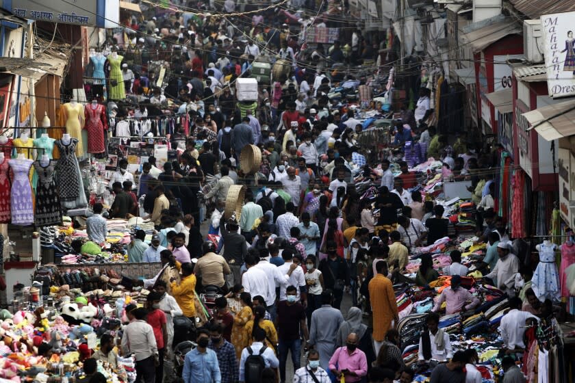 FILE - Indians wearing face masks as a precaution against the COVID-19, crowd a market, in Mumbai, India, on Jan. 7, 2022. The United Nations estimated Monday, july 11, 2022 that the world's population will reach 8 billion on Nov. 15 and that India will replace China as the world's most populous nation next year. (AP Photo/Rajanish Kakade, File)