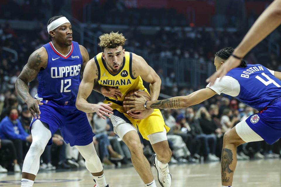 Indiana Pacers guard Chris Duarte, center, drives between Los Angeles Clippers guards Eric Bledsoe, left, and Brandon Boston Jr. during the first half of an NBA basketball game in Los Angeles, Monday, Jan. 17, 2022. (AP Photo/Ringo H.W. Chiu)