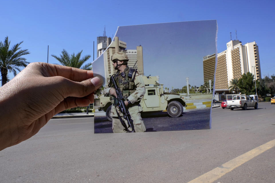 A photograph of a U.S. Army soldier standing guard in Firdous square in front of the Sheraton, left, and Palestine hotels after they came under rocket attack Friday, July 2, 2004 is inserted into the scene at the same location Friday, March 10, 2023, 20 years after the American led invasion on then country and subsequent war. (AP Photo/Hadi Mizban)