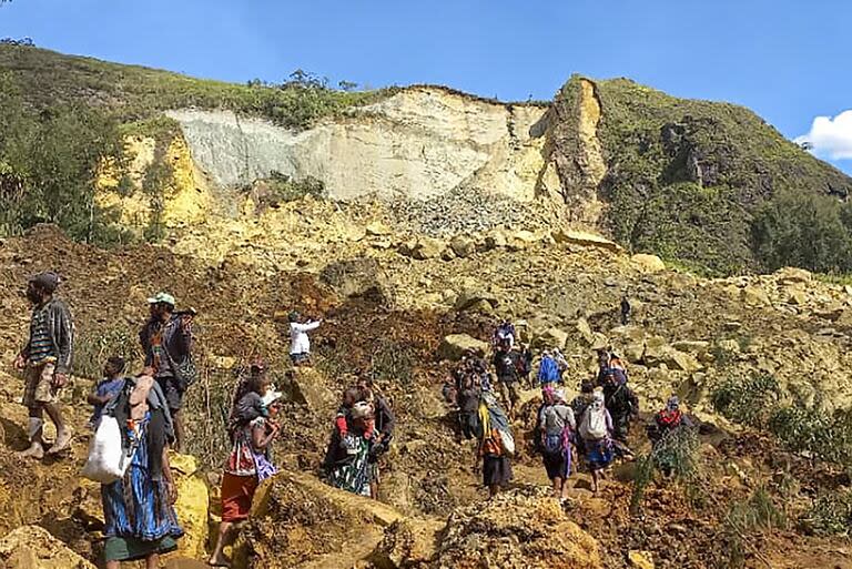 En esta foto proporcionada por el PNUD Papúa Nueva Guinea, los aldeanos buscan a través de un deslizamiento de tierra en la aldea de Yambali en las tierras altas de Papúa Nueva Guinea, el domingo 26 de mayo de 2024.