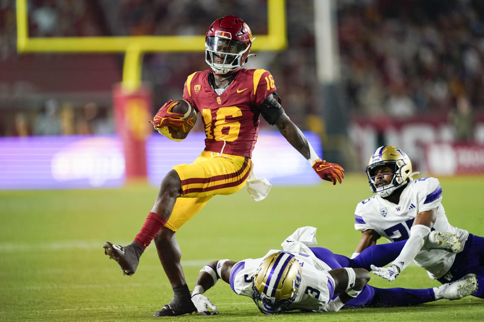 Southern California wide receiver Tahj Washington gets away from Washington safety Mishael Powell, bottom, and cornerback Elijah Jackson during the second half of an NCAA college football game Saturday, Nov. 4, 2023, in Los Angeles. (AP Photo/Ryan Sun)