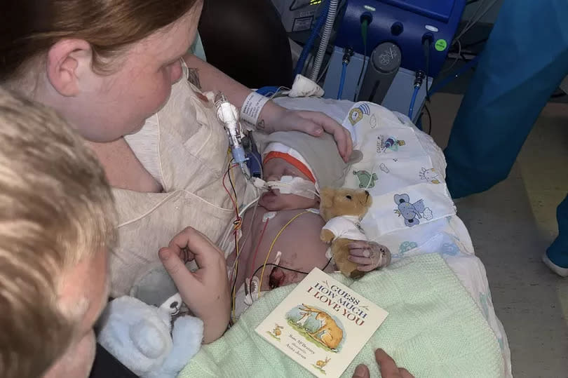 Amelia and Luke with their baby Theo after his treatment was stopped