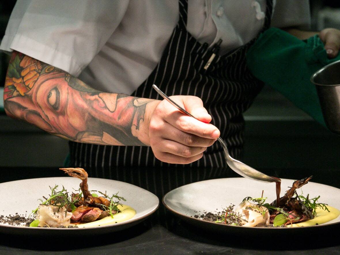 A chef puts the finishing touches on a plate for Vancouver's Dine Out Festival. (Vision Event Photography - image credit)