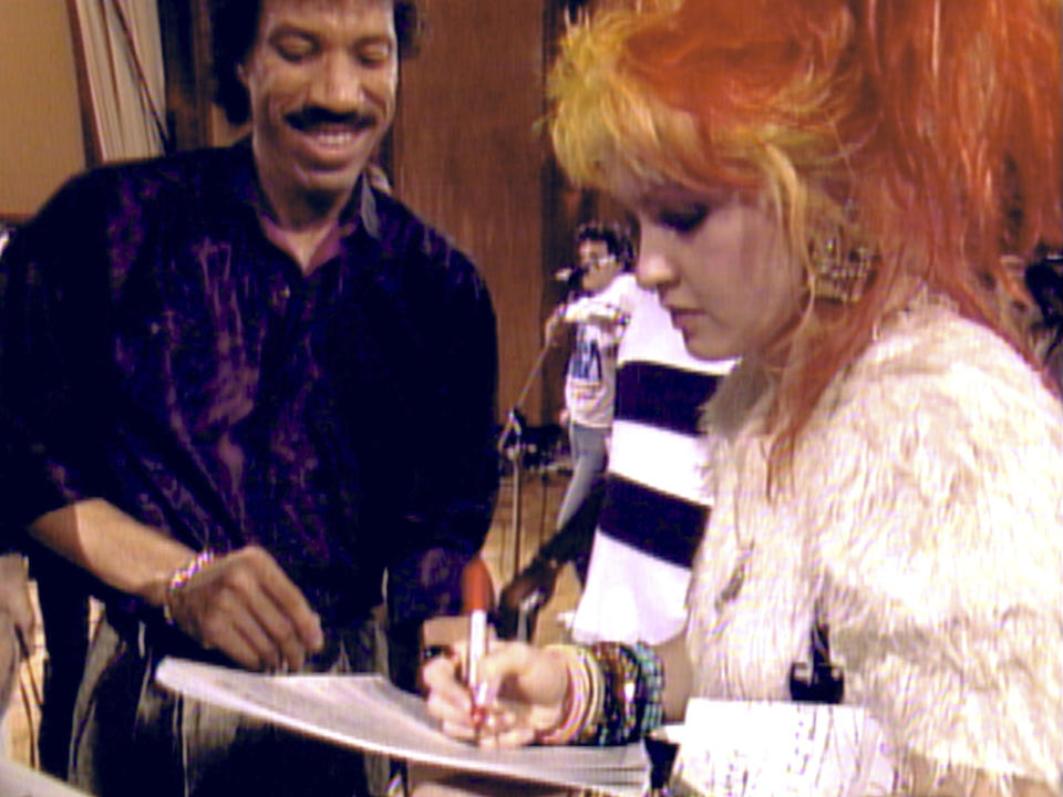 This image released by Netflix shows Lionel Richie, left, and Cyndi Lauper in a scene from "The Greatest Night in Pop." (Netflix via AP)