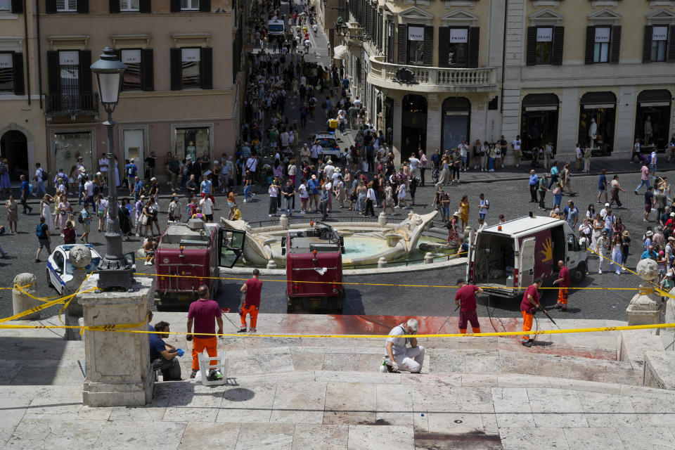 Rome municipality workers clean the Spanish Steps after activists dumped red paint over them protesting against violence on women, in Rome, Wednesday, June 26, 2024. (AP Photo/Andrew Medichini)