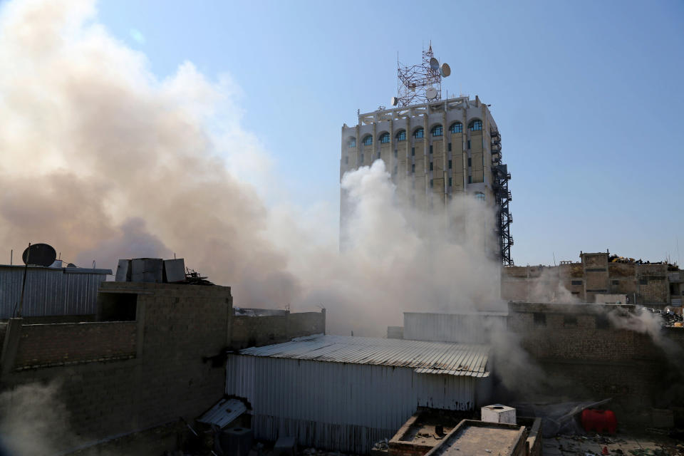 Smoke rises after a parked car bomb went off at a commercial center in Khilani Square in central Baghdad, Iraq, Wednesday, Feb. 5, 2014. Multiple bombings rocked central Baghdad on Wednesday, striking mainly near the heavily fortified Green Zone where key government offices are located and killing at least 16 people, Iraqi officials said. (AP Photo/Karim Kadim)