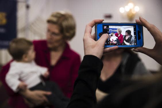 Warren holds a baby during a selfie line in Philadelphia. She had promised to take photos early on in her speech: