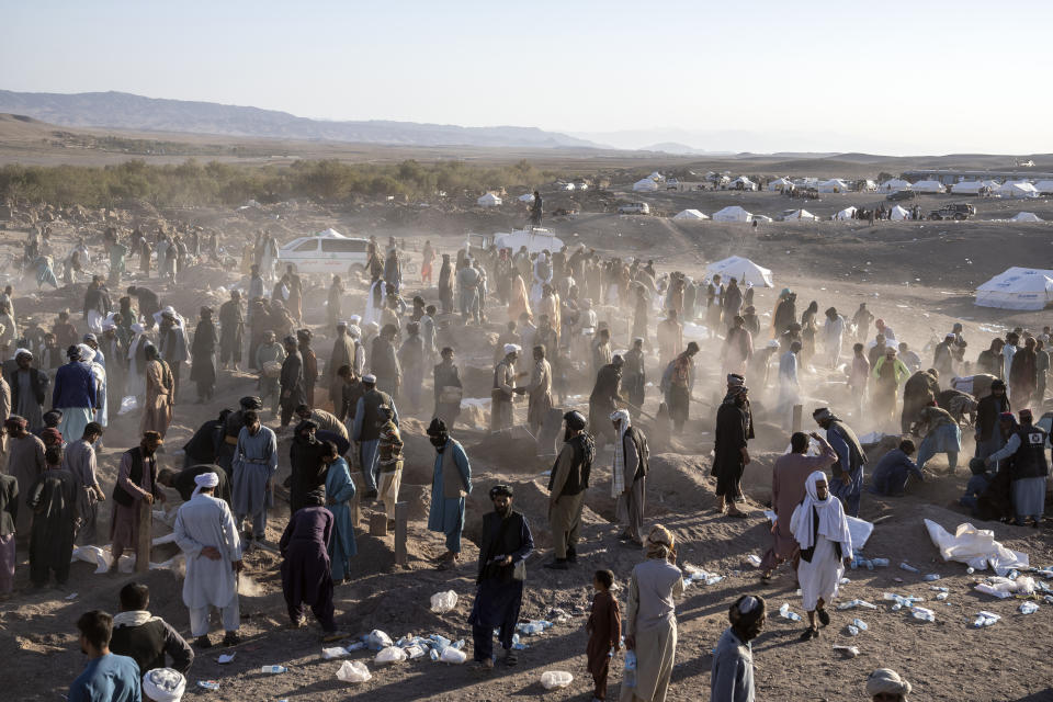 Afghans bury hundreds of people killed in an earthquake at a burial site, in a village in Zenda Jan district in Herat province, western of Afghanistan, Monday, Oct. 9, 2023. Saturday's deadly earthquake killed and injured thousands when it leveled an untold number of homes in Herat province. (AP Photo/Ebrahim Noroozi)