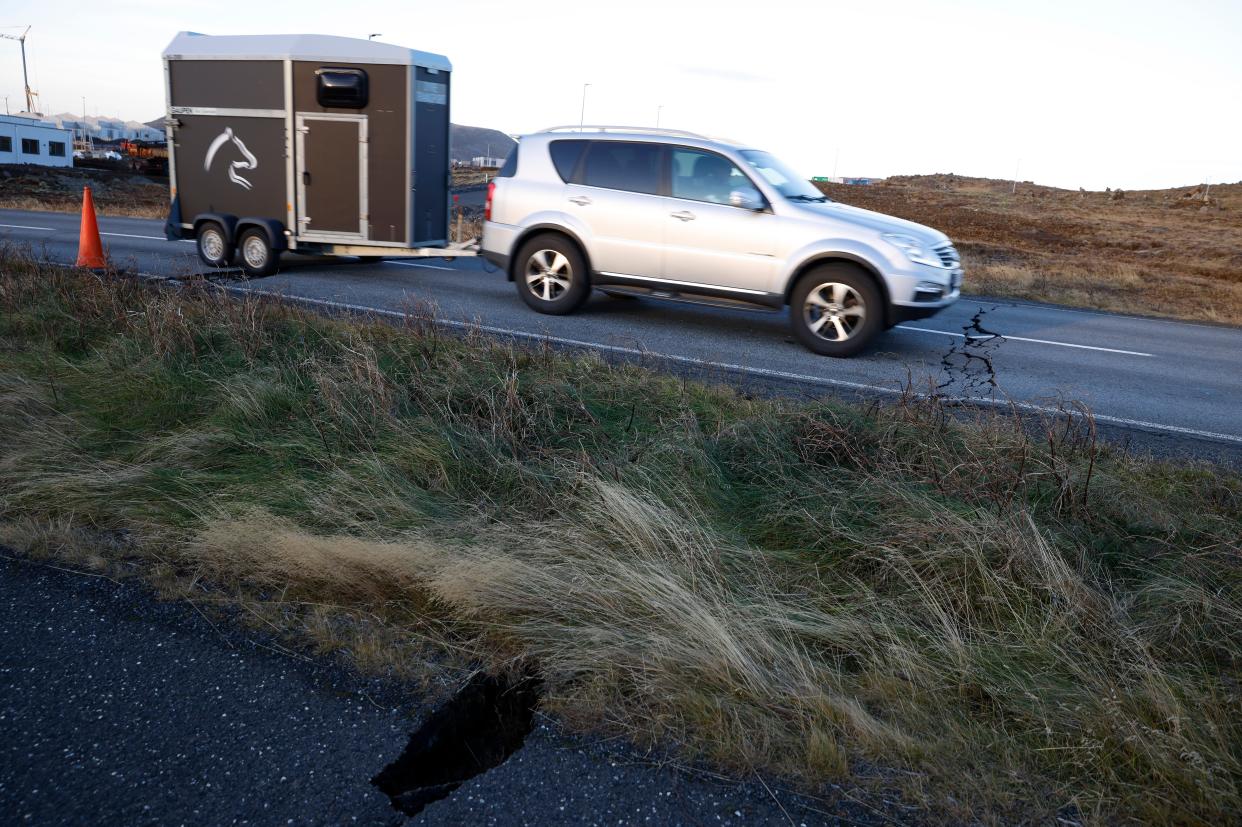 A car drives toward a crack in a road in the town of Grindavik, Iceland on Monday 13 November 2023 following seismic activity (AP)