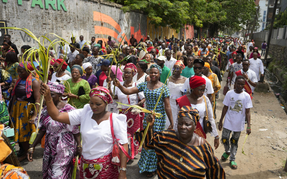 FILE - Catholic faithfuls march carrying Palm fronds to commemorate Palm Sunday, which marks the entry of Jesus Christ into Jerusalem, on the streets of Lagos, Nigeria, Sunday, April 2, 2023. Nonbelievers in Nigeria said they perennially have been treated as second-class citizens in the deeply religious country whose 210 million population is almost evenly divided between Christians dominant in the south and Muslims who are the majority in the north. (AP Photo/Sunday Alamba)