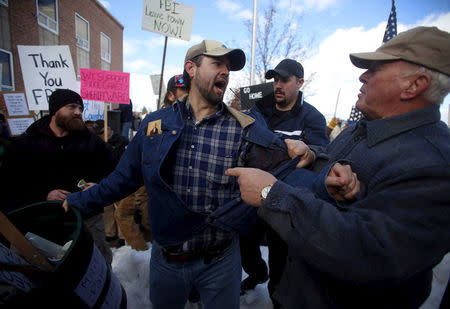 A scuffle is broken up by law enforcement between pro-militia supporter John Parker Jr. (C) and former Harney County Sheriff and anti-militia demonstrator David Glerup (R) during a protest outside the Harney County Courthouse in Burns, Oregon February 1, 2016. REUTERS/Jim Urquhart