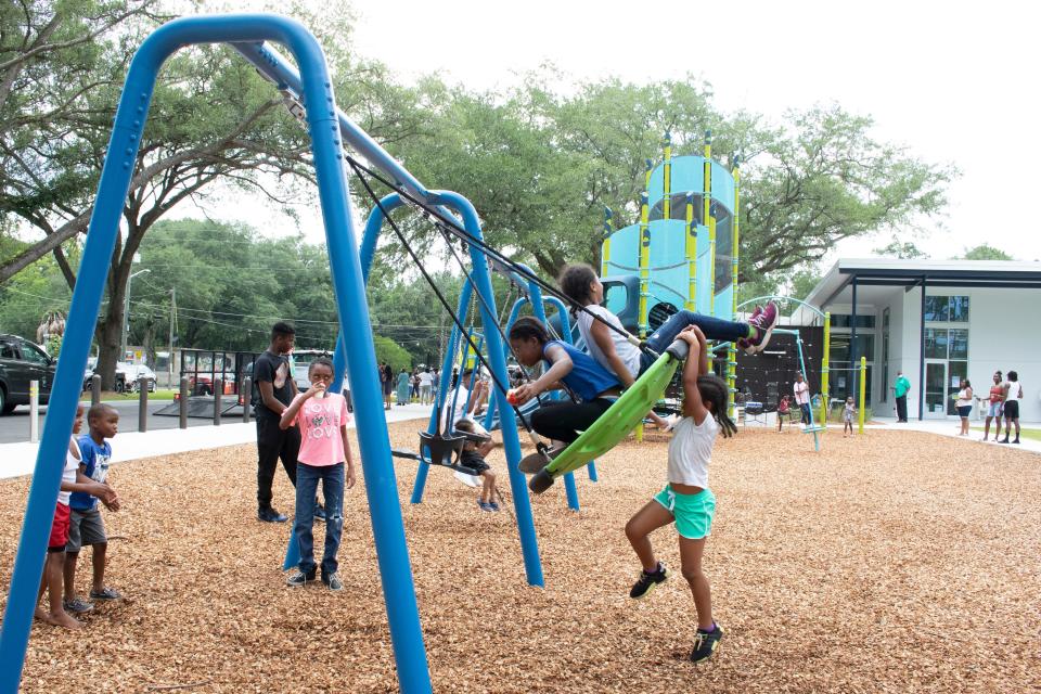 A group of kids play together on playground amenities during the official grand opening ceremony of the newly rebuilt Clarence R. Kelly Community Center and Park on Northeast Eighth Avenue in Gainesville on June 19. (Lawren Simmons/Special to the Guardian)