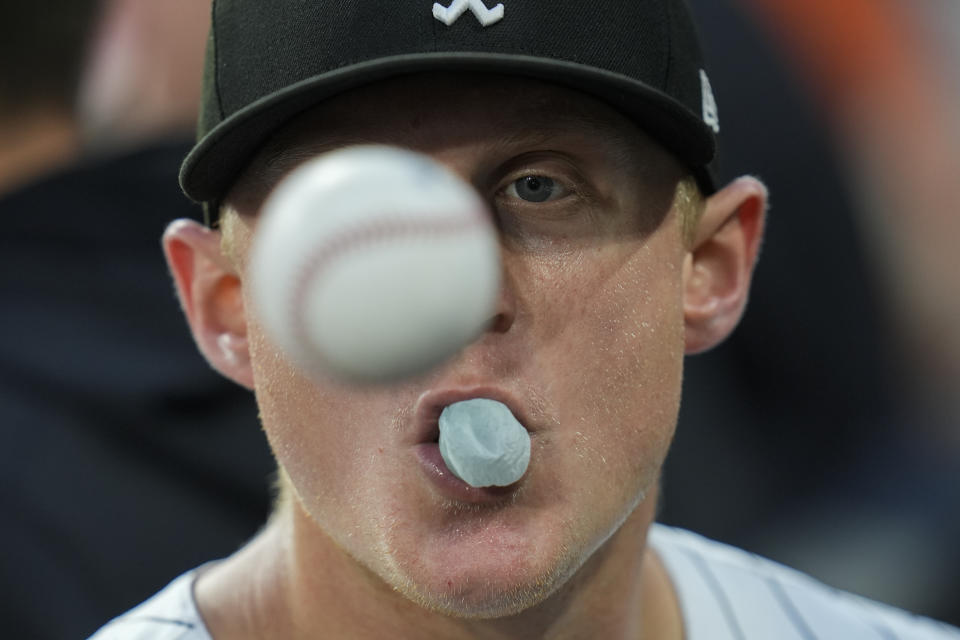 Chicago White Sox's Andrew Vaughn tosses a ball and blows a gum bubble in the dugout before a baseball game against the Colorado Rockies, Friday, June 28, 2024, in Chicago. (AP Photo/Erin Hooley)