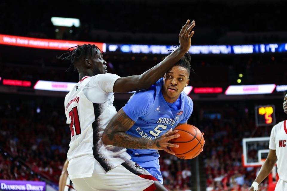 North Carolina forward Armando Bacot (5) drives against North Carolina State forward Ebenezer Dowuona during the second half of the game at PNC Arena.