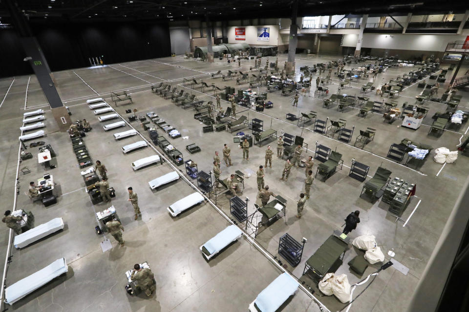 U.S. Army soldiers from Fort Carson, Col., and Joint Base Lewis-McChord (JBLM) work to set up a field hospital inside CenturyLink Field Event Center, Tuesday, March 31, 2020, in Seattle. Soldiers from the 627th Army Hospital at Fort Carson, will join soldiers from JBLM to staff the 250-bed hospital to be used for non-COVID-19 cases, allowing local hospitals additional space for patients affected by the coronavirus outbreak. Officials said that the field hospital is expected to be ready to receive patients next week. (AP Photo/Elaine Thompson)