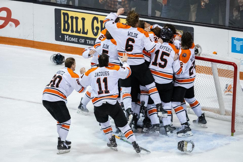 RIT men's hockey players celebrate after defeating American International in the Atlantic Hockey championship game.