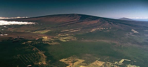 Mauna Loa Volcano towers above Kilauea Volcano (caldera in left center) in a 1985 photograph.