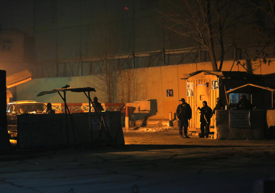 Afghan security personnel stand guard at the gate near the site of an explosion in Kabul