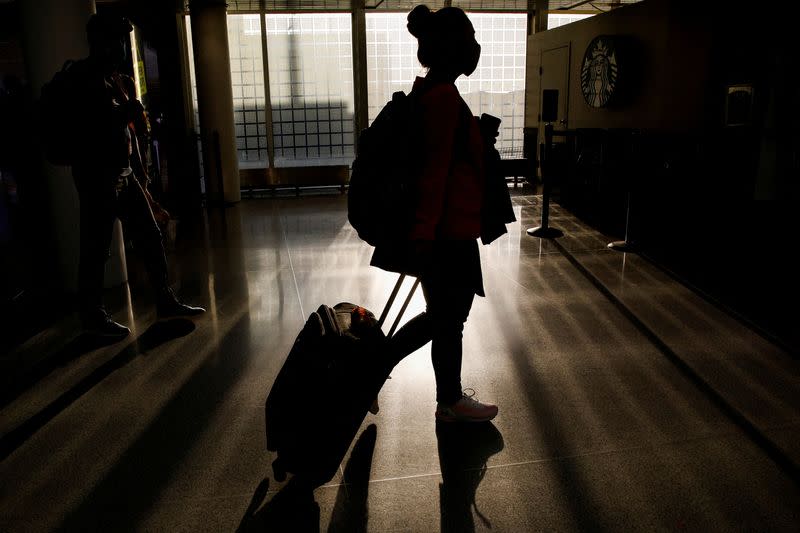 FILE PHOTO: A traveler walks through O'Hare International Airport ahead of the Thanksgiving holiday in Chicago, Illinois