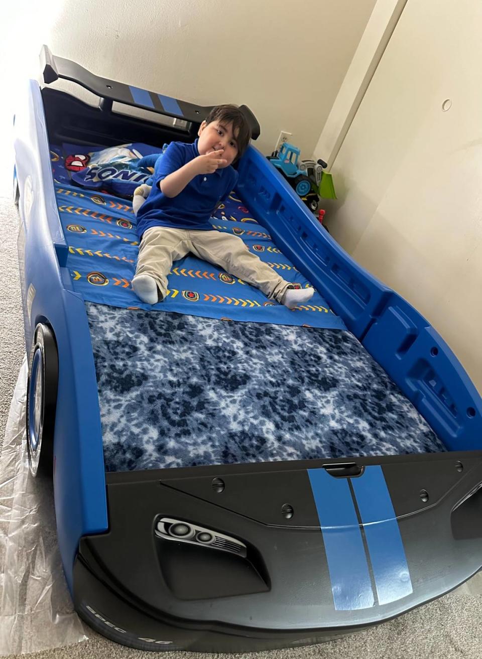 Lucas Salazar, 5, in his new turbo racing car bed that he received from a Wish Book donor in 2023. Lucas, who lives with his family in Weston, has undergone extensive treatment after being diagnosed with lymphoblastic leukemia in 2019.