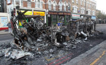 A destroyed bus sits in the Tottenham high road after being set upon by arsonists on Saturday night.