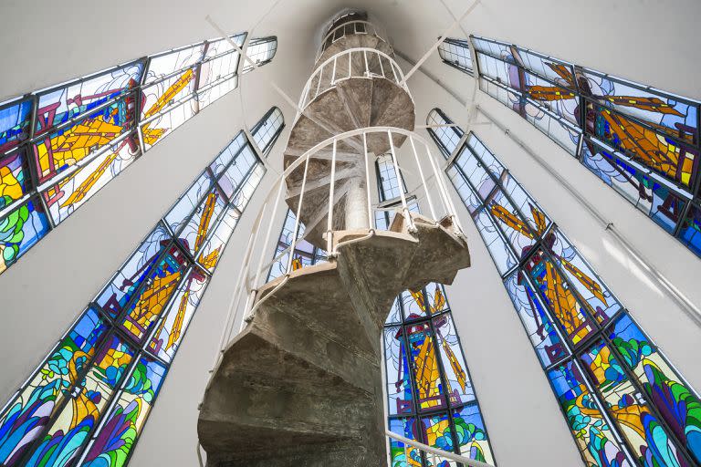 La escalera caracol lleva a lo alto de la torre donde se ubican las aspas del molino. Son 37 escalones rodeados por vitrales protegidos para evitar el daño del granizo y las palomas