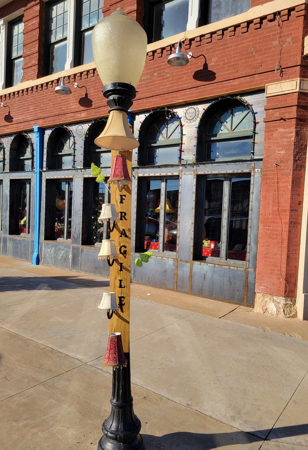 A street lamp in downtown Chickasha is decorated with tiny lampshades as a tribute to the famed leg lamp prop from the 1983 movie "A Christmas Story" on Nov. 28, 2023. The street lamp is just down Chickasha Avenue from the Chickasha Leg Lamp, a 50-foot-tall homage to the film's iconic leg lamp.