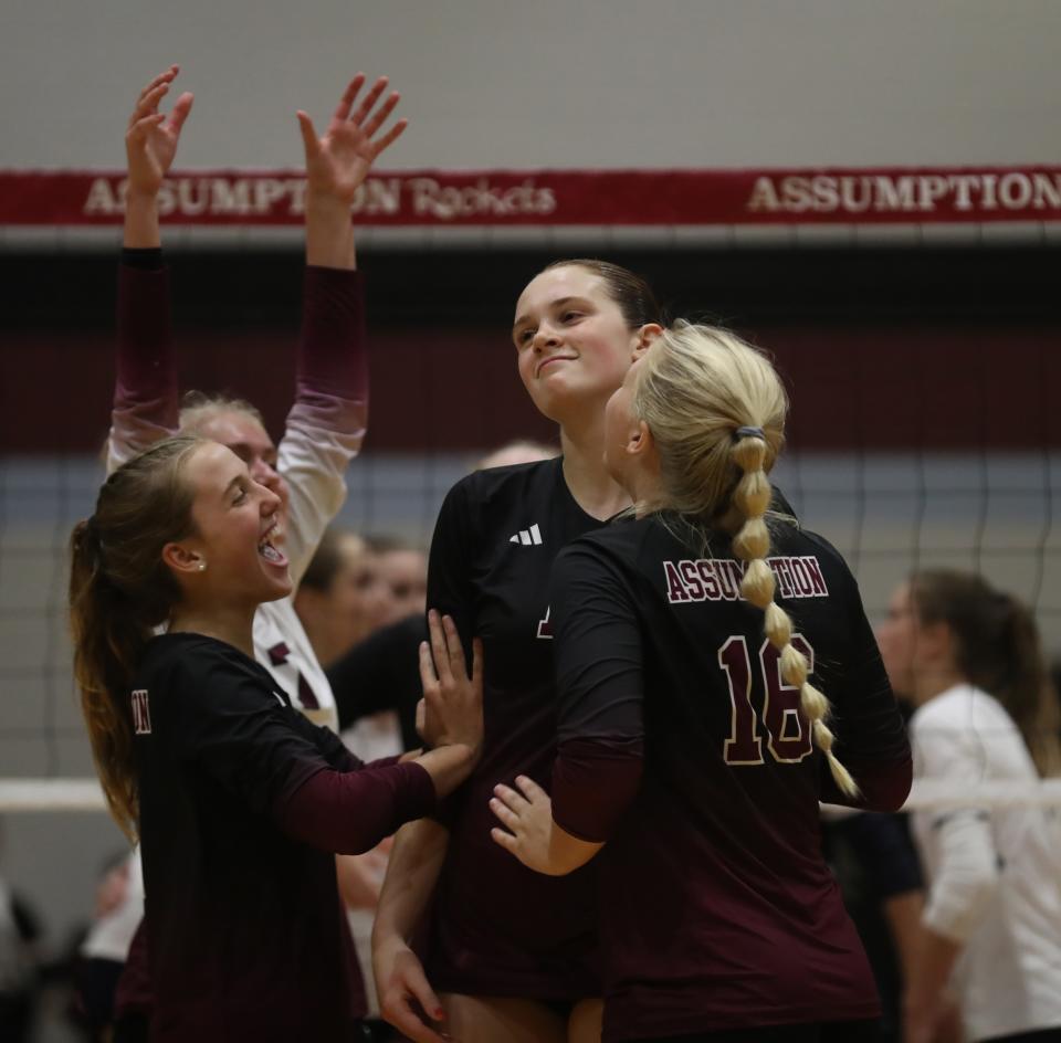 Assumption’s Bailey Blair is congratulated by teammates after a point against Sacred Heart.