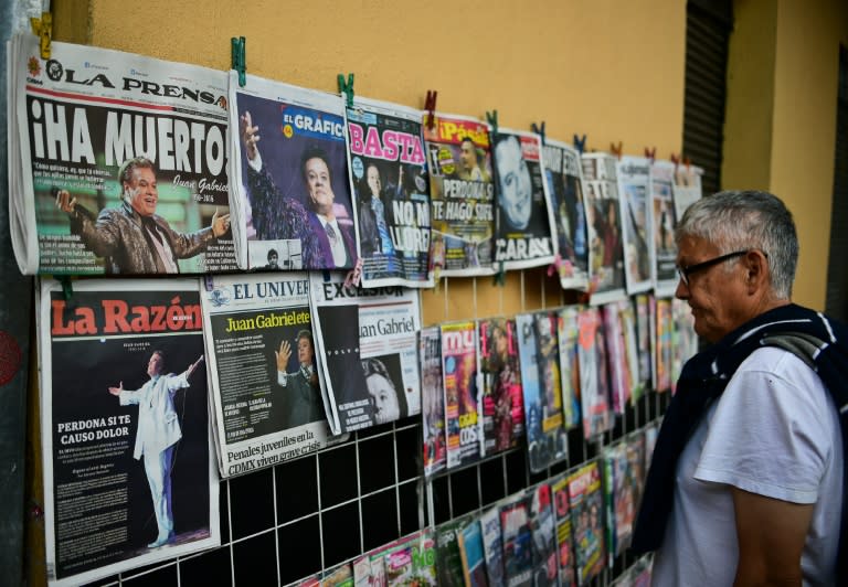 A man looks at newspaper frontpages with the news of the death of Mexican singer Juan Gabriel in Plaza Garibaldi in Mexico City, on August 29, 2016