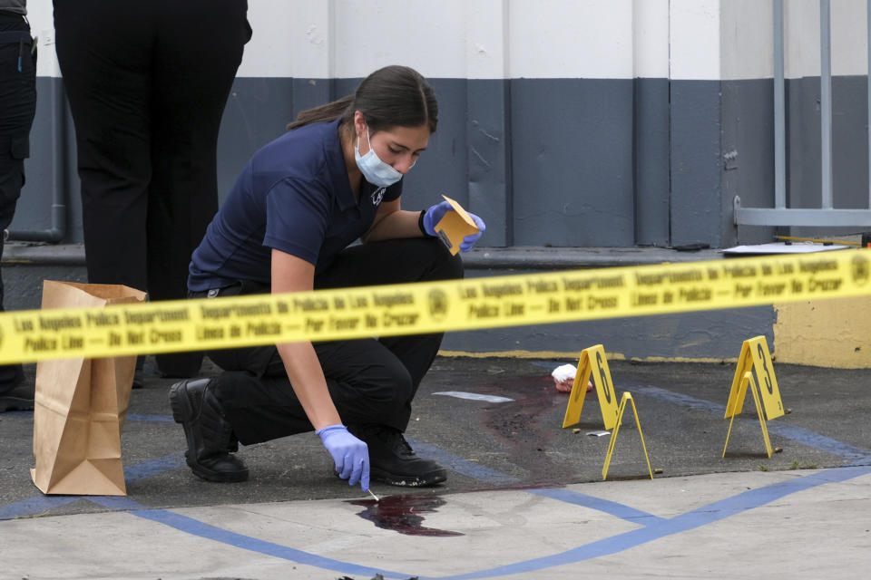 LAPD crime investigators collect evidence at one of the scenes of a triple shooting, a Shell gas station in the North Hollywood section of Los Angeles on Thursday, July 25, 2019. A gunman shot five people, killing three, in two attacks early Thursday in Los Angeles that police say took the lives of two of his family members and an acquaintance. A manhunt was underway for Gerry Dean Zarragoza, 26, who may be driving a blue Jeep Liberty with paper license plates, police spokesman Officer Drake Madison said. (David Crane/The Orange County Register via AP)