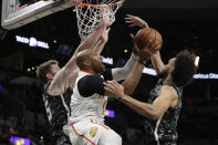 Atlanta Hawks guard Vince Carter, center, drives to the basket between San Antonio Spurs defenders Jakob Poeltl, left, and Derrick White, right, during the first half of an NBA basketball game in San Antonio, Friday, Jan. 17, 2020. (AP Photo/Eric Gay)