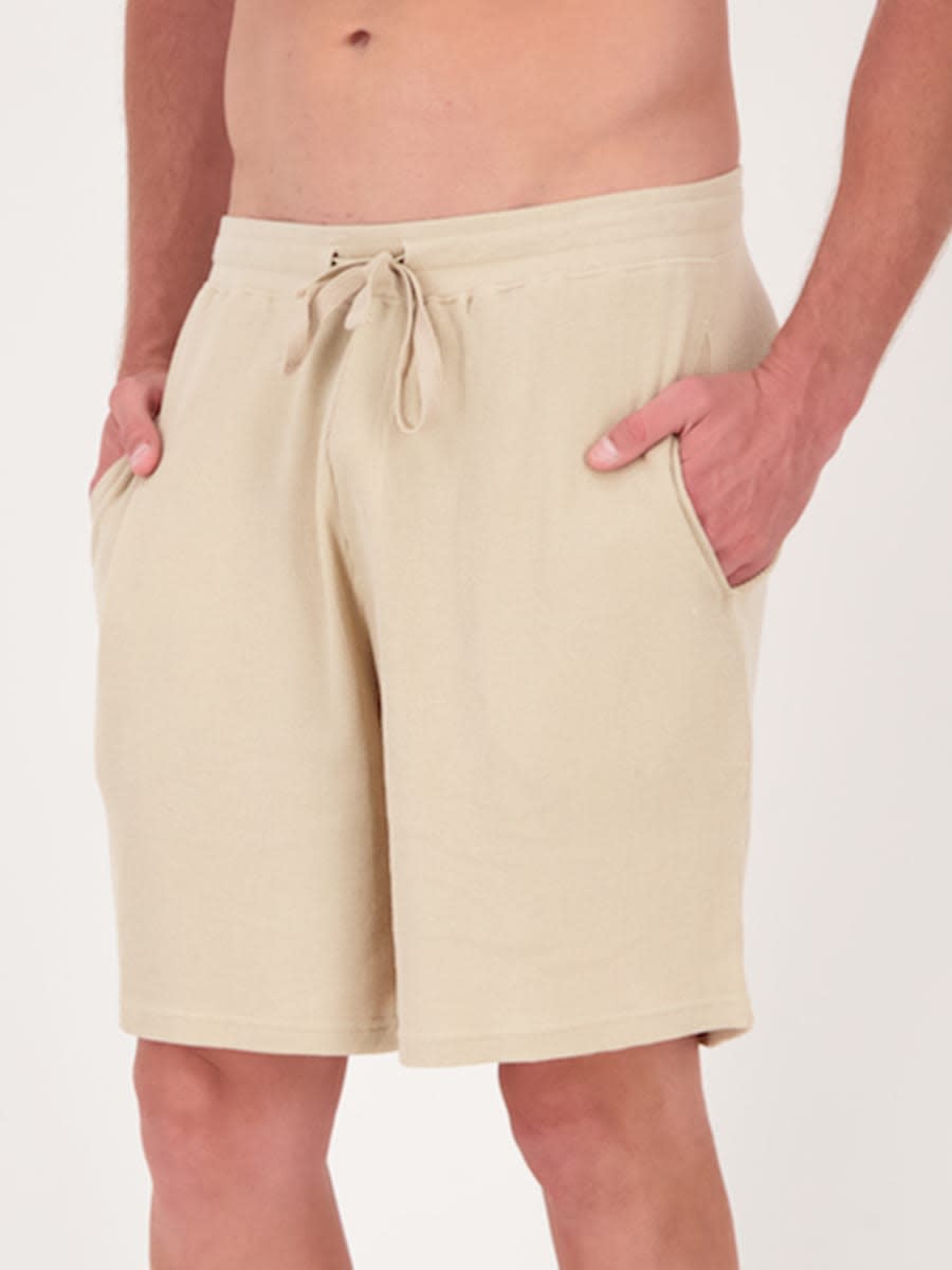 Lower torso of man wearing cream or beige waffle cotton shorts, $10 from Best & Less