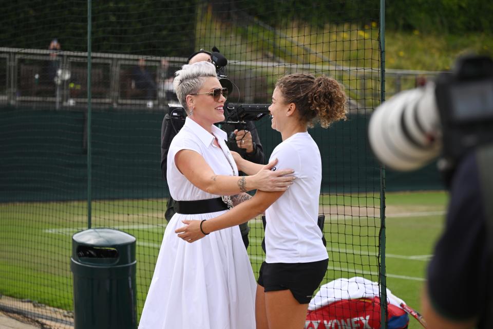 Pink receives a warm welcome to Wimbledon from tennis player Jasmine Paolini of Italy.