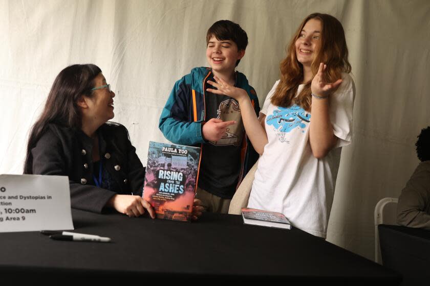 Los Angeles, CA - April 19: Author Paula Yoo talks to twins Abby and Zach Vasko, 13, after the Do the Right Thing: Social Justice and Dystopias in Young Adult Fiction panel on the Young Adult Stage during the LA Times Book Festival at USC campus on Friday, April 19, 2024 in Los Angeles, CA. (Michael Blackshire / Los Angeles Times)