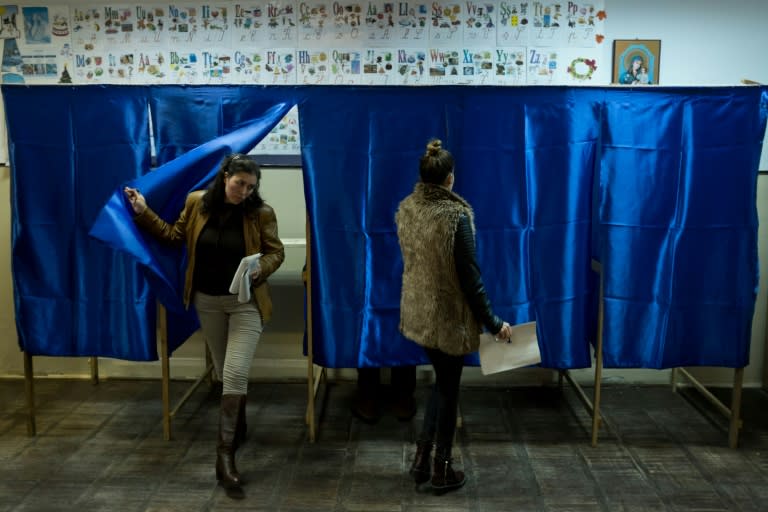 A mother and her daughter cast their votes, on December 11, 2016, in the village of Vidra, Romania