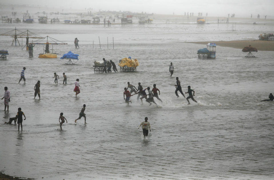 People play on the Marina beach flooded with sea water on the Bay of Bengal coast in Chennai, India, Wednesday, Oct. 31, 2012. More than 100,000 people were evacuated from their homes Wednesday as a tropical storm approached southern India from the Bay of Bengal, officials said the storm, with wind speeds of up to 100 kilometers (60 miles) per hour, was expected to reach land later Wednesday. (AP Photo/Arun Sankar K)