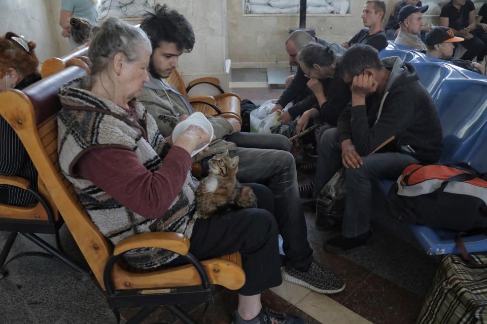 People wait for an evacuation train at a railway station in Kherson (AP)