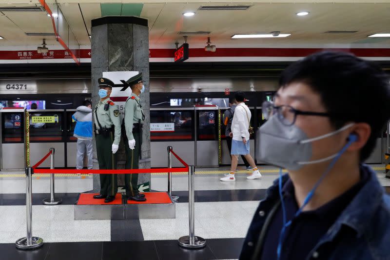 Paramilitary police officers keep watch at a station of Line 1 of the metro that runs past the Great Hall of the People, the venue of the upcoming National People's Congress