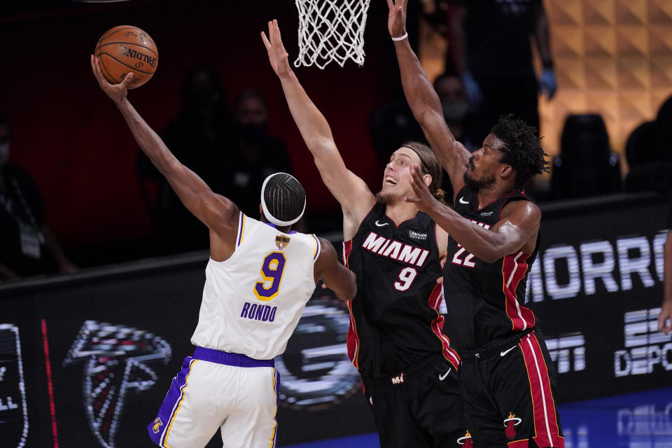 Miami Heat's Kelly Olynyk (9) and Miami Heat's Jimmy Butler (22) attempt to block Los Angeles Lakers' Rajon Rondo (9) during the second half in Game 3 of basketball's NBA Finals, Sunday, Oct. 4, 2020, in Lake Buena Vista, Fla. (AP Photo/Mark J. Terrill)