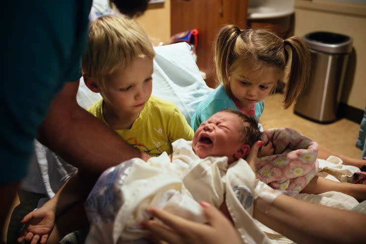 Maya Loper, 2, and her brother Ethan, 3, are introduced to their new baby brother, Gavin, by mom Ashley. (Photo: Sara Naomi Lewkowicz for Yahoo News)