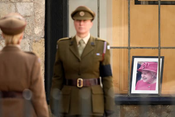 LONDON, ENGLAND - SEPTEMBER 19: A soldier stands to attention while a tribute to Queen Elizabeth II shows in a window behind at Westminster Abbey on September 19, 2022 in London, England. Elizabeth Alexandra Mary Windsor was born in Bruton Street, Mayfair, London on 21 April 1926. She married Prince Philip in 1947 and ascended the throne of the United Kingdom and Commonwealth on 6 February 1952 after the death of her Father, King George VI. Queen Elizabeth II died at Balmoral Castle in Scotland on September 8, 2022, and is succeeded by her eldest son, King Charles III.  (Photo by Christopher Furlong/Getty Images)