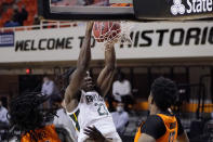 Baylor forward Jonathan Tchamwa Tchatchoua (23) dunks between Oklahoma State guard Isaac Likekele, left, and forward Matthew-Alexander Moncrieffe, right, in the first half of an NCAA college basketball game Saturday, Jan. 23, 2021, in Stillwater, Okla. (AP Photo/Sue Ogrocki)