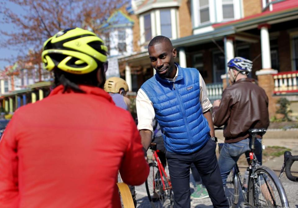 In this March 26, 2016 photo, Baltimore mayoral candidate DeRay Mckesson, right, chats with bicyclists as he canvasses in the Charles Village neighborhood of Baltimore. Mckesson is known on the national stage for his role in Black Lives Matter, but he’s struggling as he campaigns for mayor in his hometown.