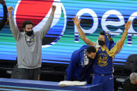 Injured Golden State Warriors guard Klay Thompson, from left, celebrates with Juan Toscano-Anderson and Stephen Curry during the second half of an NBA basketball game against the Cleveland Cavaliers in San Francisco, Monday, Feb. 15, 2021. (AP Photo/Jeff Chiu)